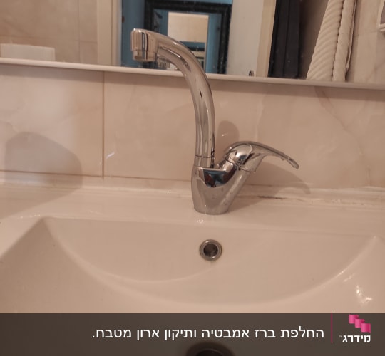 ברז כרום מותקן על כיור לבן בחדר אמבטיה